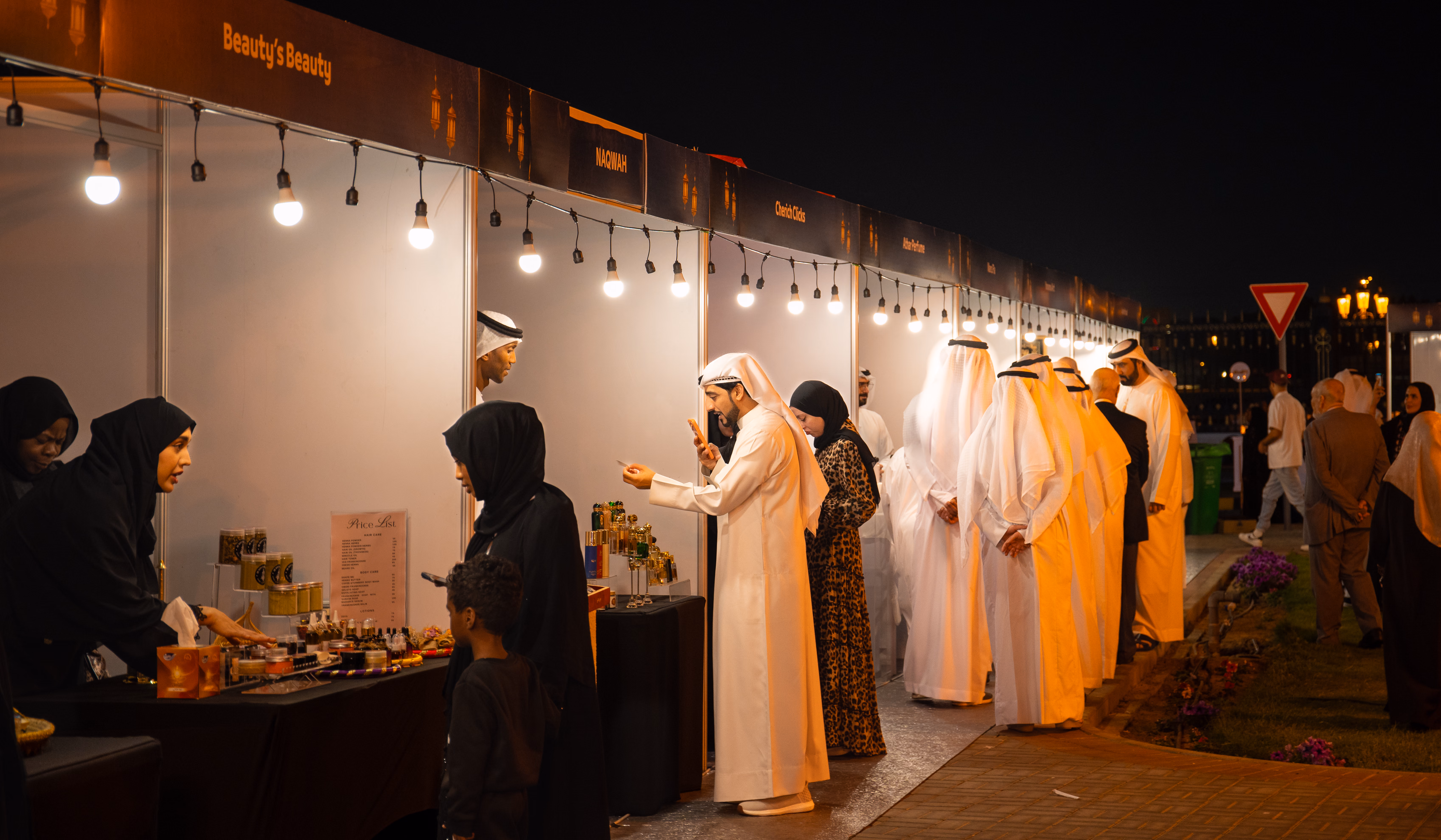 Visitors browsing the lantern-lit stalls along the festival row after dark.